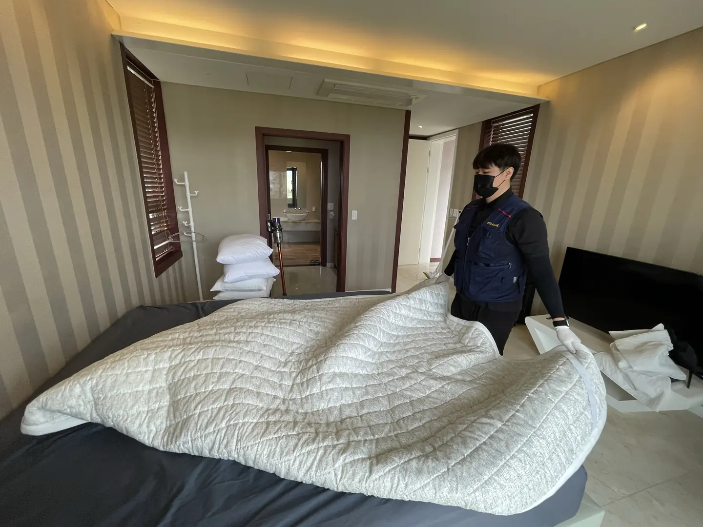 침실의 침구를 정리하는 모습