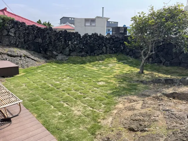 잔디 조각이 놓인 주택 정원