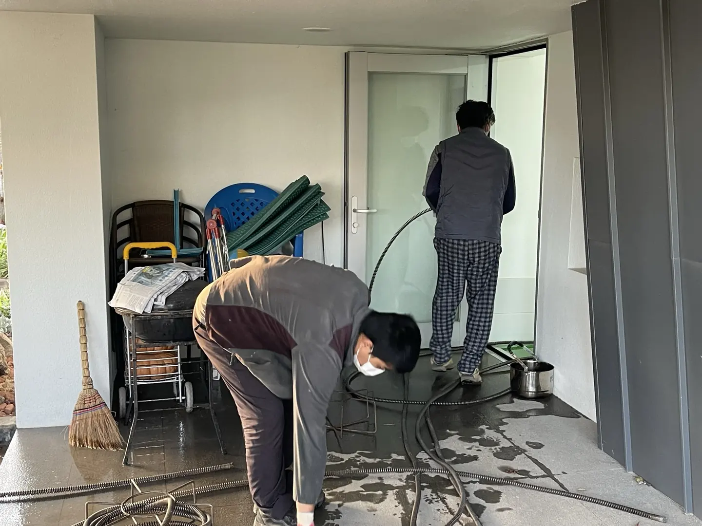 두 직원이 함께 바닥을 물청소하는 모습